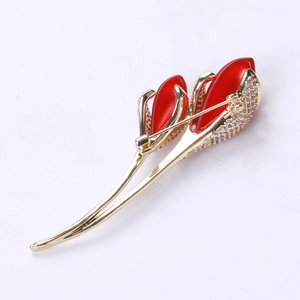 Detailed back view of a gold tulip brooch with red enamel petals and white zircon accents