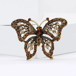 Elegant gold butterfly brooch with champagne rhinestones on a modern white display
