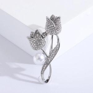 Broche tulpe argentée élégante avec cristaux scintillants et perle blanche sur socle blanc