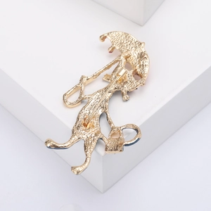 Detailed back view of a golden alloy cat brooch with a metal pin and textured finish