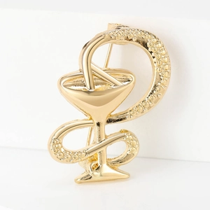 Makro-Detail einer goldenen Schale der Hygieia Brosche mit strukturierter Schlange und Politur