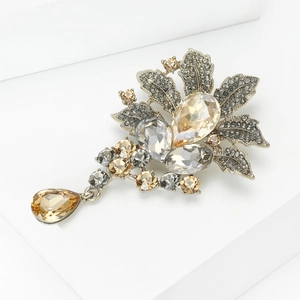 Luxurious floral crystal brooch with champagne teardrop pendant on minimalist pedestal