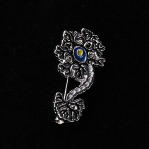 Retro silver metal brain nerve brooch with blue enamel evil eye on black background
