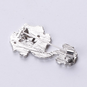 Detail view of the silver metal brooch back with secure pin clasp and textured surface