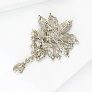 Silver leaf brooch with intricate back texture and sparkling pear-shaped pendant drop
