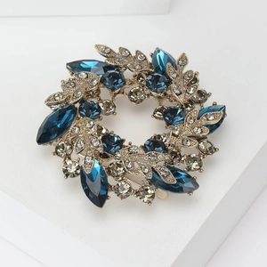Close-up of Baroque wreath brooch featuring navy blue crystals and grey rhinestones