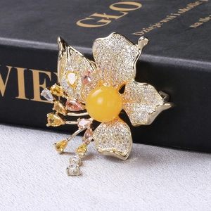 Detailed macro view of luxury flower brooch with yellow stones and zircon tassels
