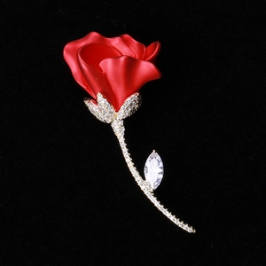 Détail de la broche rose rouge avec tige dorée et oxydes de zirconium sur fond noir mat
