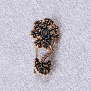 Macro shot of a neuron-shaped enamel brooch with golden alloy base and blue core detail