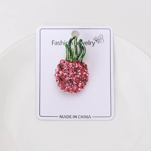 Nahaufnahme einer Drachenfrucht Brosche mit rosa Strasssteinen und grüner Emaillierung