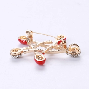 Detailed view of the back of a gold star brooch with safety pin and red enamel