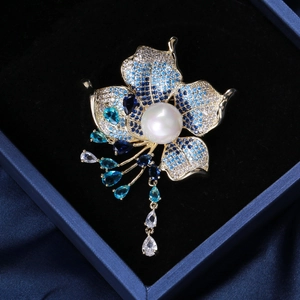 Detailed close-up of a blue zircon flower brooch with a large white pearl and tassels