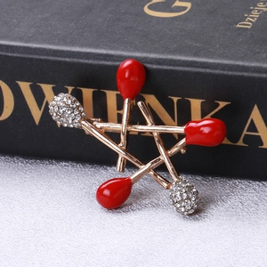 Close-up of alloy star brooch with red enamel and pavé rhinestones on a black book