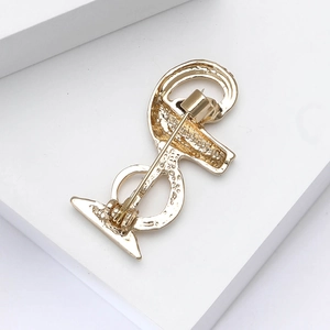 Macro view of gold vintage snake brooch back showing security pin clasp and textured metal