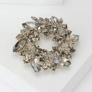 Detailed macro view of baroque wreath brooch with smoked grey and champagne crystals