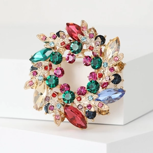 Macro shot of luxury crystal wreath brooch with colorful rhinestones on golden alloy