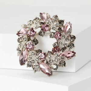 Detail of crystal wreath brooch with pink marquise stones and silver metal leaves