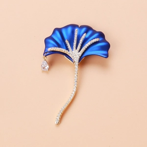 Detail of blue matte ginkgo leaf brooch featuring white zircon inlay and pear-shaped drop