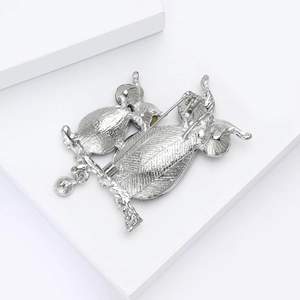 Dettaglio del retro della spilla gufo con trama in metallo argento e chiusura di sicurezza