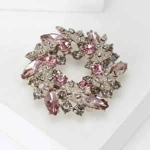 Detailed view of luxury baroque crystal wreath brooch with pink and smoke gray stones