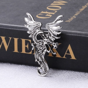 Macro shot of antique silver dragon brooch showing detailed scales and gothic textures