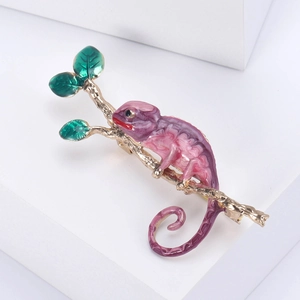 Vue détaillée de la broche caméléon en dégradé de violet et rose sur branche dorée