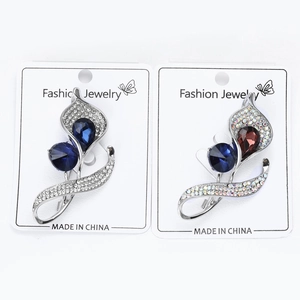 Close-up of sparkling rhinestone orchid brooches in blue and coffee floral crystal designs
