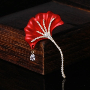 Detail shot of red ginkgo leaf brooch with zircon micro-pave and a clear water-drop pendant