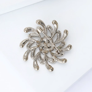 Vue arrière d'une broche fleurie dorée avec design rayon de soleil et épingle de sûreté