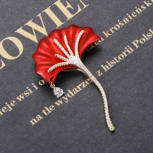 Macro detail of red ginkgo leaf brooch with pavé zircons and a teardrop pendant