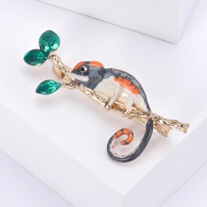 Broche caméléon rétro en émail coloré sur une branche dorée avec feuilles vertes