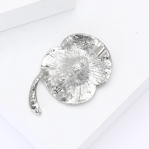 Detail view of the silver enamel poppy brooch back with secure safety pin clasp