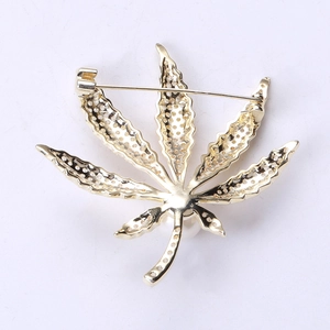 Makro-Detail der goldenen Ahornblatt-Brosche Rückseite mit Sicherheitsnadel und Zirkon
