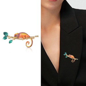 Broche caméléon en émail coloré avec branche dorée sur un blazer noir élégant