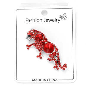 Macro shot of silver-tone leopard brooch with red rhinestones on display card