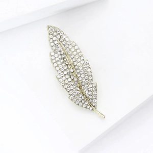 Detailed macro view of luxurious gold feather brooch with sparkling crystal rhinestones