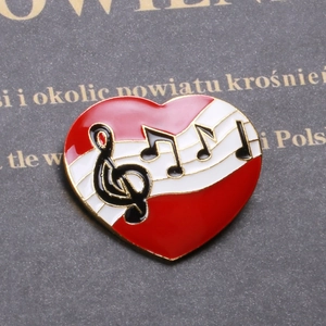 Élégante broche cœur en émail rouge avec notes de musique noires et bordure dorée raffinée