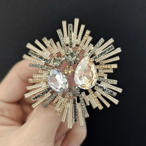 Détails d'une broche de luxe en forme de soleil avec des cristaux en forme de poire
