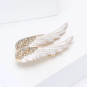 Élégantes broches ailes d'ange dorées avec détails en émail blanc et strass étincelants