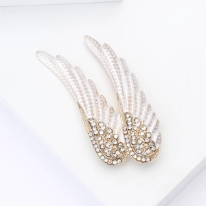 Vue détaillée d'une broche ailes d'ange en émail blanc avec cristaux irisés