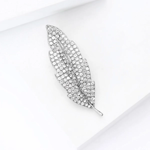 Detailed macro view of an elegant silver leaf brooch with sparkling rhinestone inlay