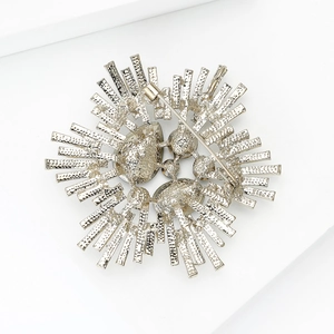 Broche baroque vintage en argent aux rayons métalliques abstraits sur fond blanc