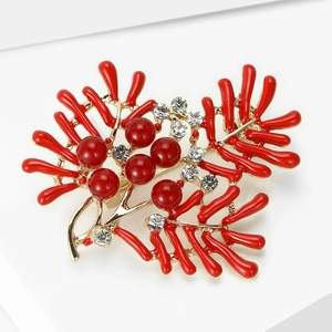 Detailed macro view of red coral brooch with gold branches and sparkling crystals