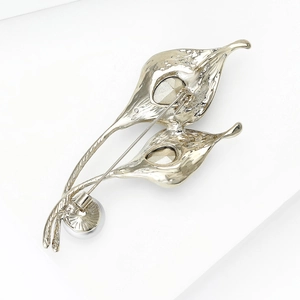 Elegant vintage gold floral brooch with leaves and white pearl on white background