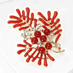 Detail of red enamel coral brooch with pearls and crystals on gold-plated base
