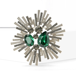 Broche baroque en argent avec pierres vert foncé et rayons de cristal scintillants