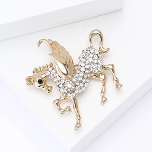 Detailed view of a golden pegasus brooch featuring sparkling white rhinestones and a black eye