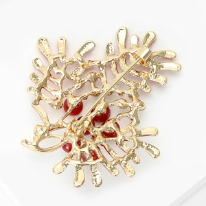 Macro shot of the sturdy gold-plated alloy back and pin closure of the coral brooch