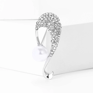 Dettaglio di elegante spilla in lega a forma di S con perla e strass scintillanti