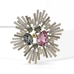 Broche baroque en cristal en forme d'étoile avec pierres roses et dorées sur fond blanc